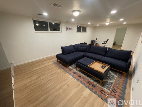 A living room with a blue couch and a wooden coffee table.