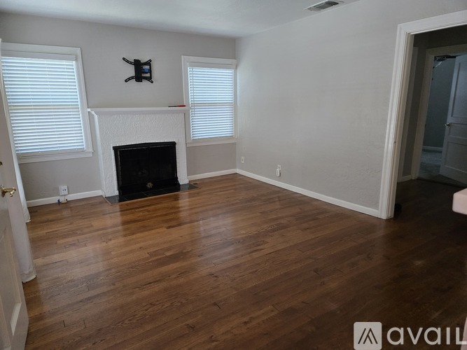 A room with a fireplace and wooden floors.