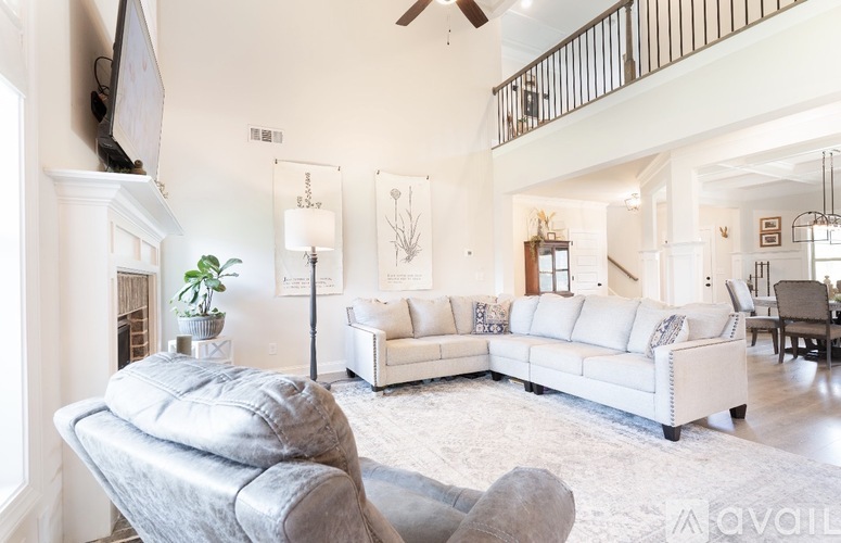 A living room with a grey couch and a white sofa.