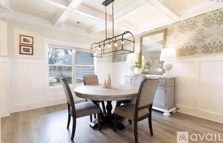 A dining room with a round table and chairs.
