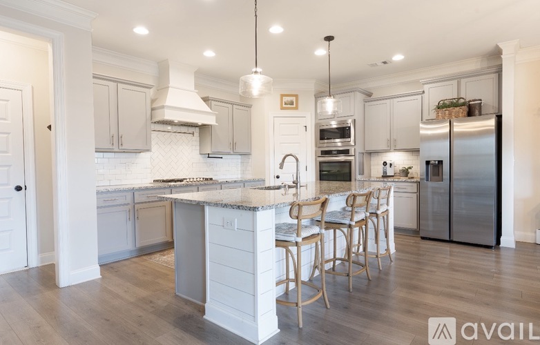 A kitchen with a center island and a refrigerator on the right.