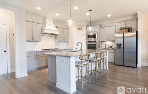 A kitchen with a center island and a refrigerator on the right.