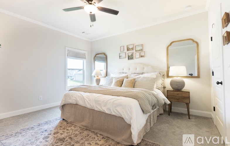 A bedroom with a large bed and a ceiling fan.