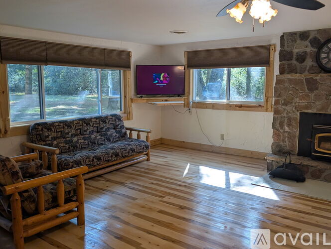 A living room with a couch, a television, and a fireplace.