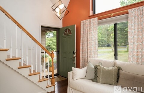 A living room with a white couch and a green door.