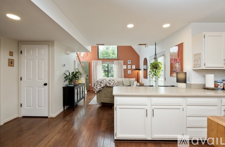 A kitchen with white cabinets and a wooden floor.