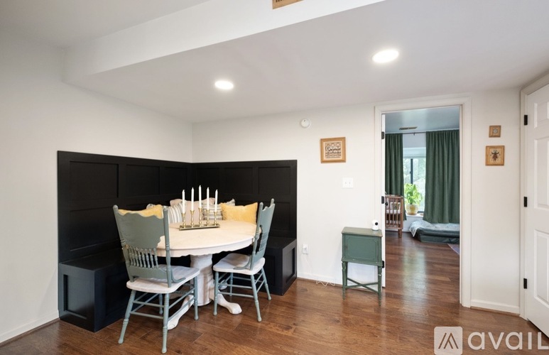 A dining room with a white table and chairs.