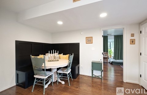 A dining room with a white table and chairs.