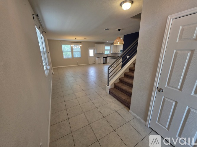 A spacious living room with a staircase leading to the upper floor.
