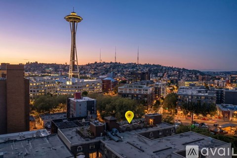 A cityscape with a prominent tower and buildings with a sunset in the background.