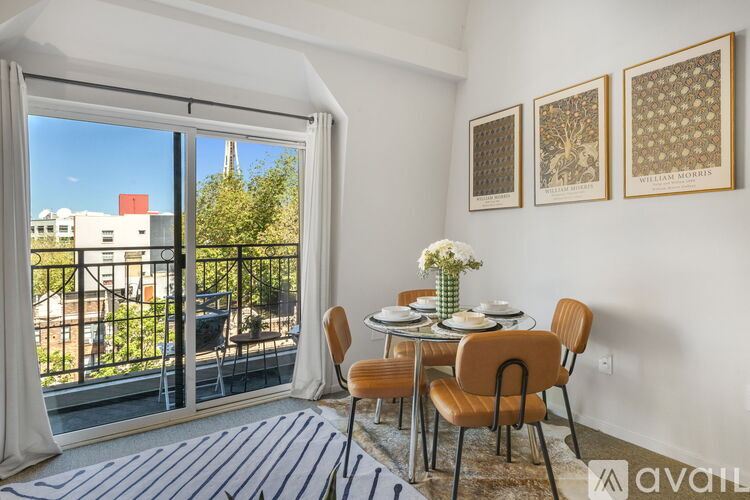 A dining room with a table set for two and a view of the outside.
