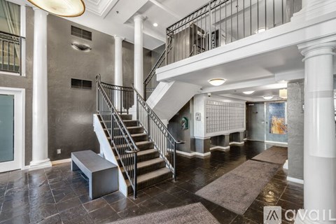 A spacious foyer with a staircase and a bench.