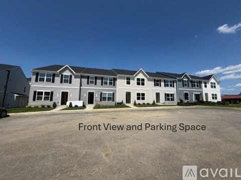 A large building with a parking lot in front.