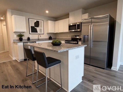 A kitchen with white cabinets and a granite countertop.