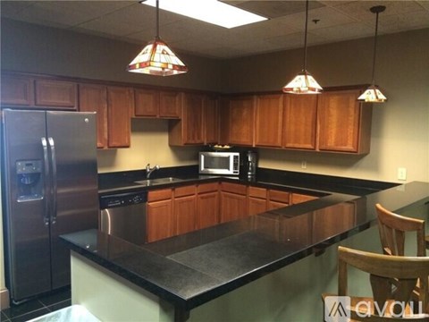 A kitchen with wooden cabinets and a black countertop.