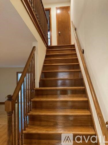 A wooden staircase with a railing on the left side.