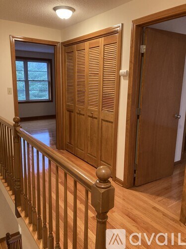 A room with wooden floors and a staircase with a wooden banister.