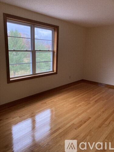 A room with a window and wooden flooring.