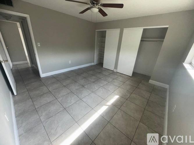 A room with a ceiling fan and tile flooring.