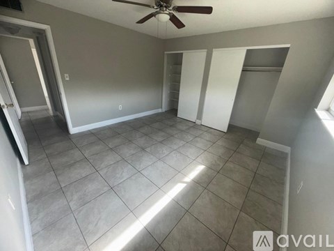 A room with a ceiling fan and tile flooring.