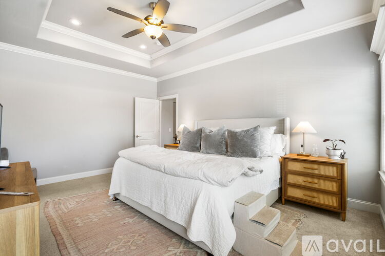 A bedroom with a bed, nightstand, and a ceiling fan.