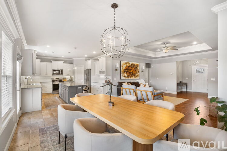 A modern dining room with a wooden table and white chairs.