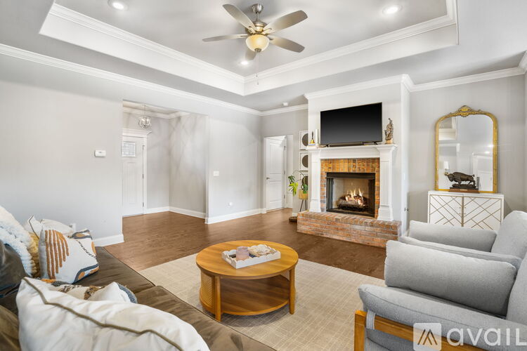 A living room with a fireplace and a television on the wall.