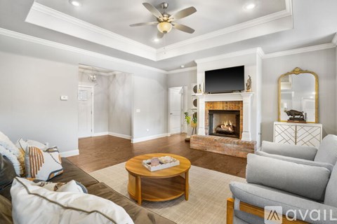 A living room with a fireplace and a television on the wall.