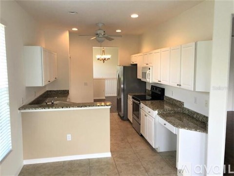 A kitchen with white cabinets and granite countertops.
