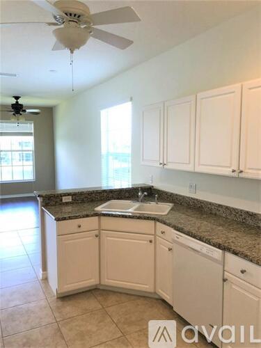 A kitchen with white cabinets and a granite countertop.
