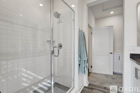 A bathroom with a walk-in shower and a white door.