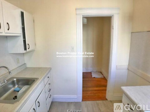 A kitchen with white cabinets and a sink.