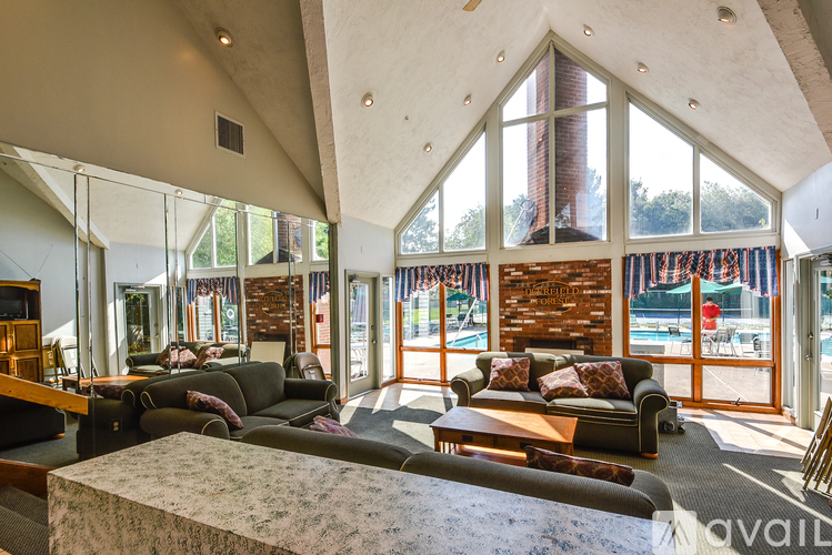 A living room with a stone fireplace and a large window.
