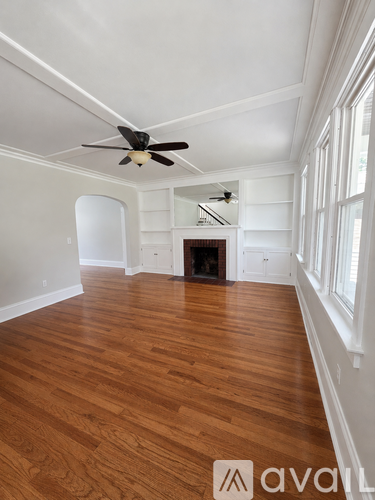 A room with wooden floors and a ceiling fan.