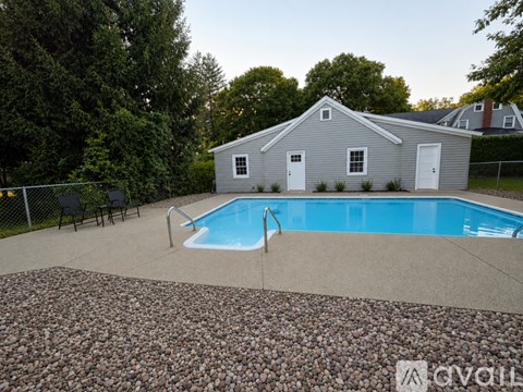 A pool in a backyard with a house in the background.