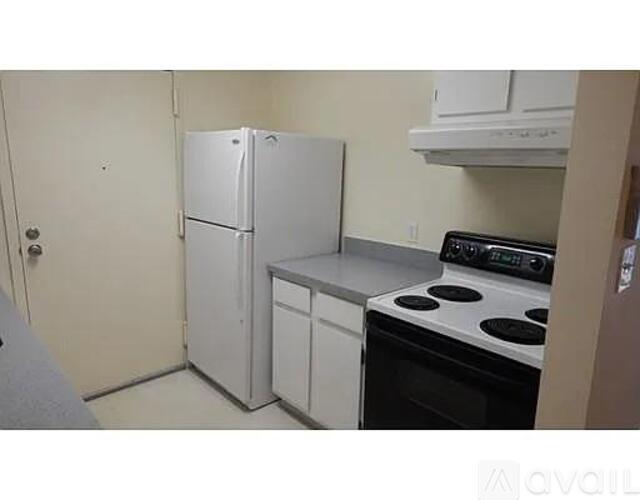 A kitchen with a white fridge, white oven, and white cabinets.