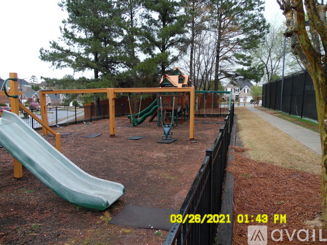 A playground with a green slide and a wooden structure.