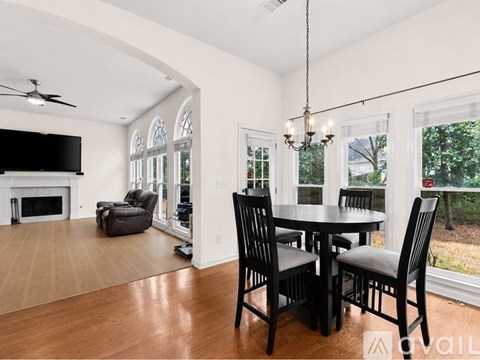 A modern dining room with a black table and chairs.