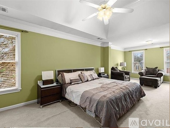 A bedroom with a large bed and a ceiling fan.