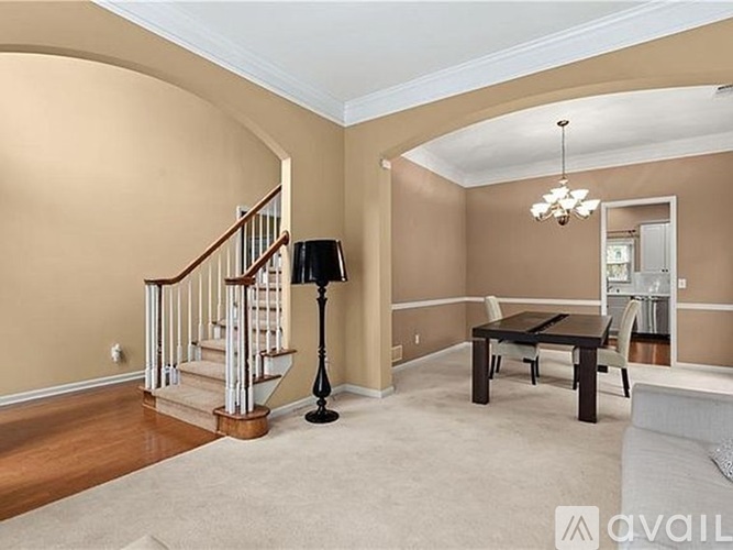 A living room with a staircase and a lamp.