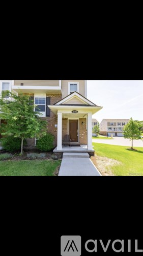A house with a front yard and a tree.