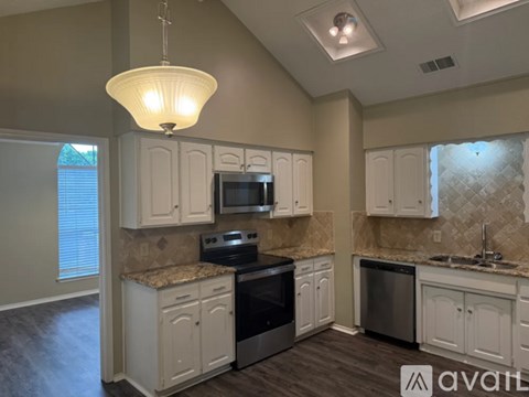 A kitchen with white cabinets and a granite countertop.