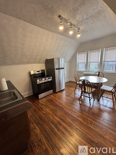 A kitchen with wood flooring and a table set for four.