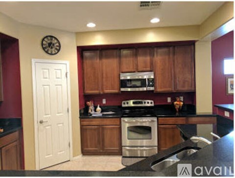 A kitchen with wooden cabinets and a black counter top.
