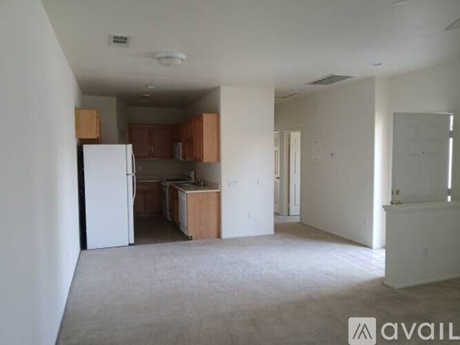 A room with a white refrigerator and wooden cabinets.