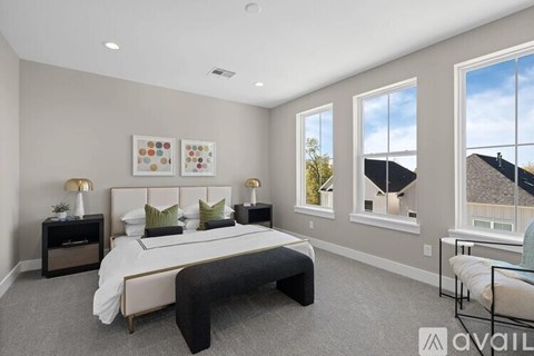 A bedroom with a large bed and a window overlooking a roof.