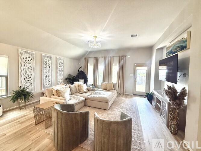 A living room with a white sofa set and a wooden floor.