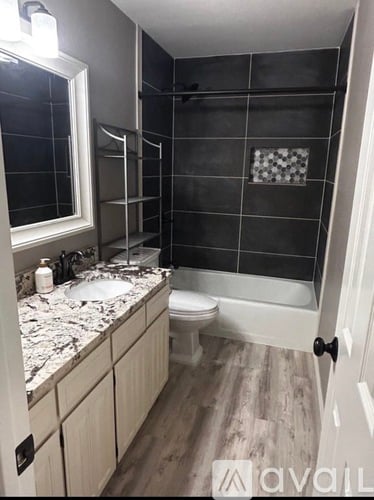 A bathroom with a toilet, sink, and bathtub.