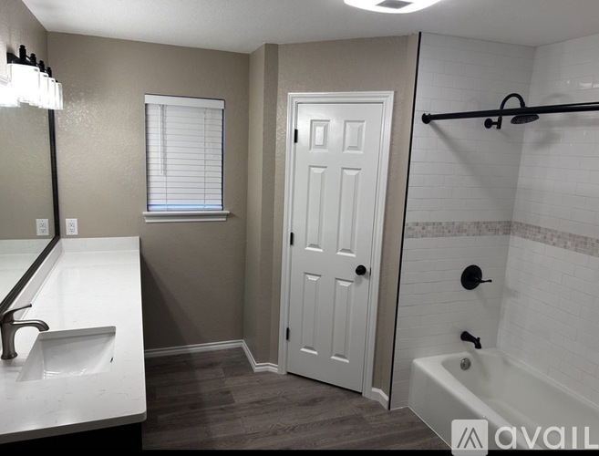 A bathroom with a white sink and a white door.
