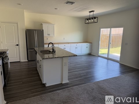 A kitchen with a refrigerator, sink, and cabinets.